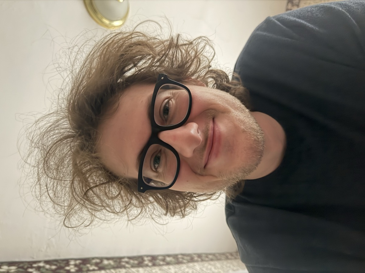 Eli Larkin smiling with spectacularly untamed hair