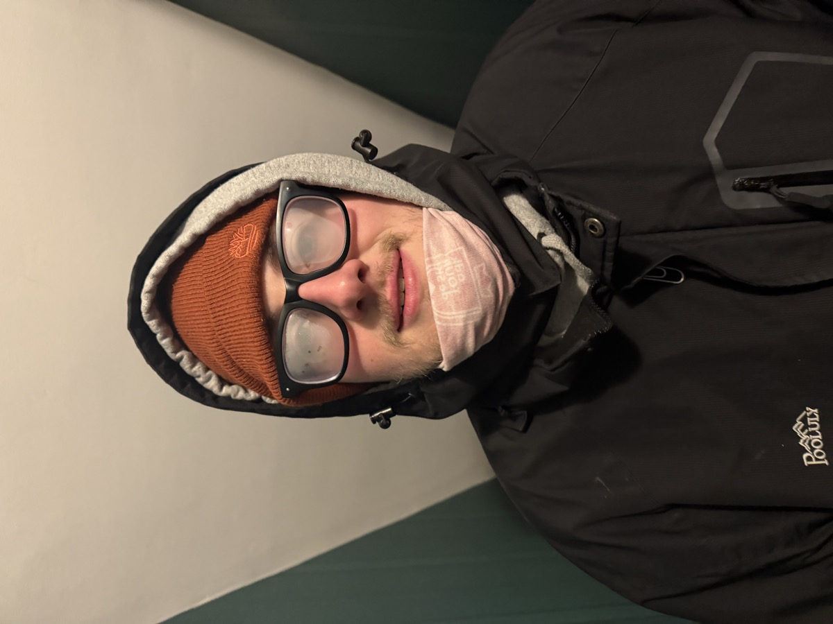 Eli Larkin bundled in a hood and beanie with completely fogged glasses