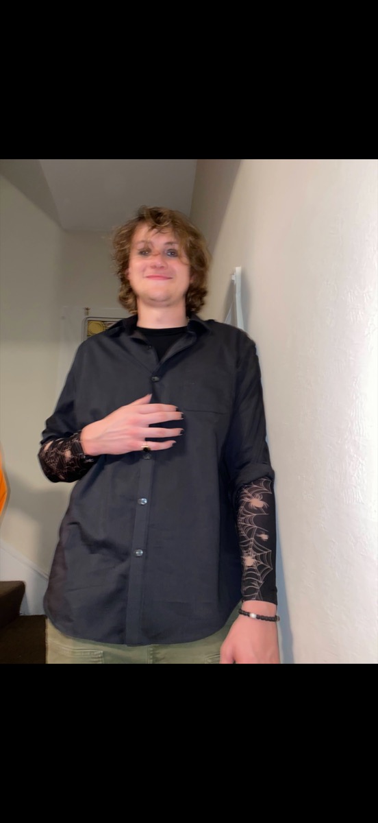 Eli Larkin in a black shirt with spiderweb sleeves